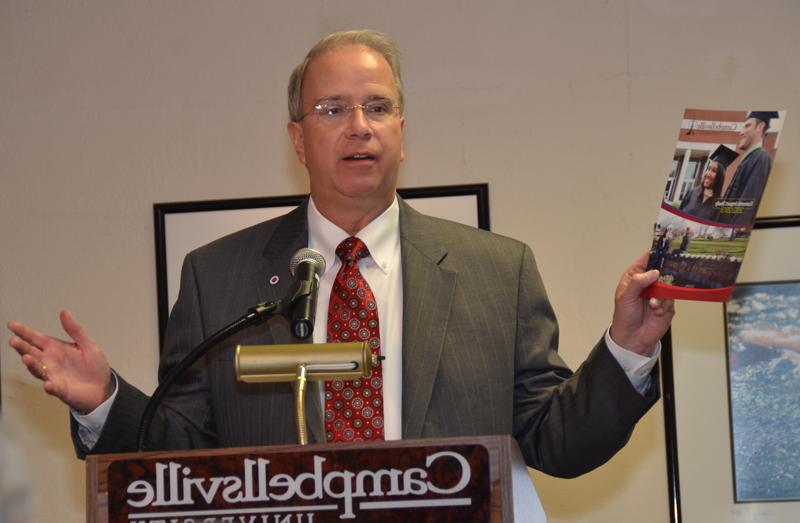 Dr. Michael V. Carter, in his 15th year as president of Campbellsville University, shows the Campbellsville/ Taylor County Chamber of Commerce, a recent economic impact story that shows CU contributed over $100 million in 2012-13 to the local economy. (Campbellsville University Photo by Drew Tucker)